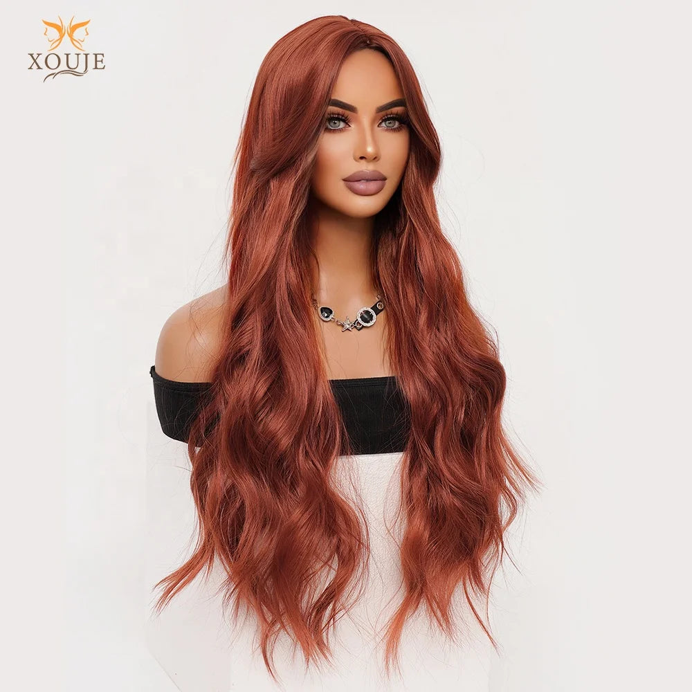A long, wavy wig in a warm coppery auburn shade displayed on a mannequin head against a plain light background. The brand name TRC is visible in the top left corner.